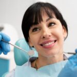 a lady is smiling after having dental crown treatment