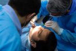 dentists examine patient's teeth